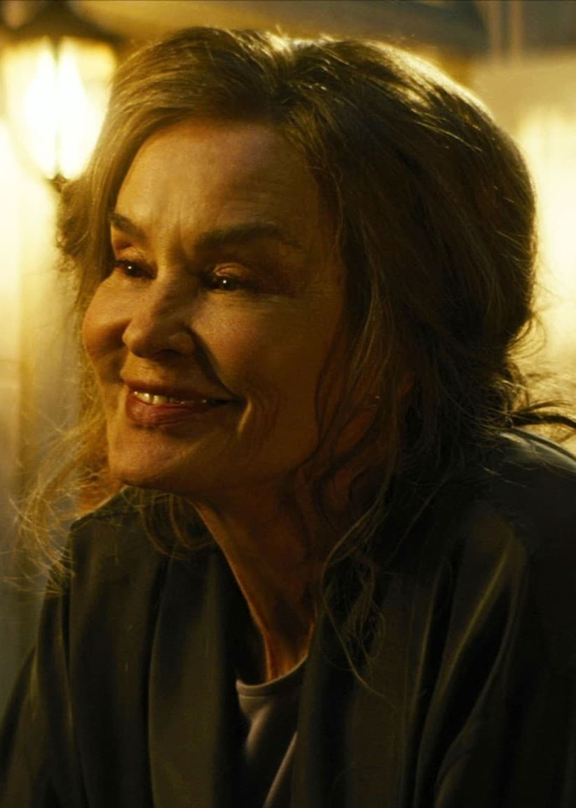 Jessica Lange och Pierce Brosnan samtalar intensivt i en mörk, upplyst miljö, en scen från filmen ”The Great Lilian Hall”.