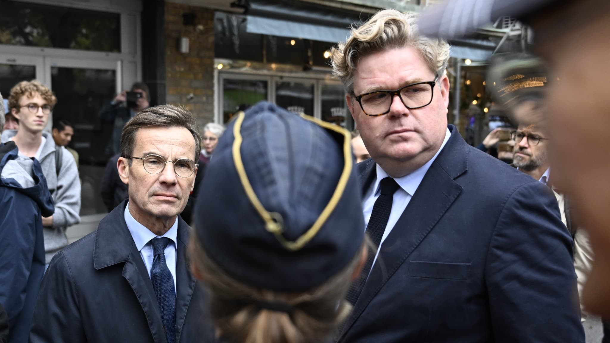 Justitieminister Gunnar Strömmer och statsminister Ulf Kristersson pratar med poliser