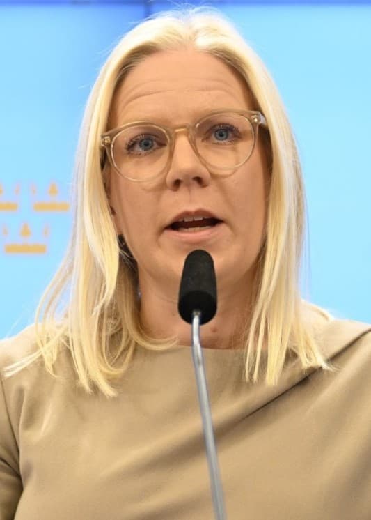 Blond kvinna talar i mikrofon.