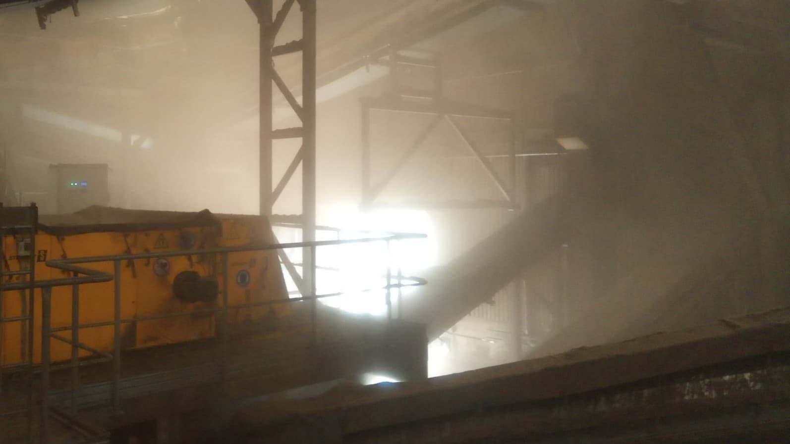 Bild inifrån Stenas anläggning i Halmstad visar en dammig och smutsig arbetsmiljö med industrimaskiner och svag belysning. 
