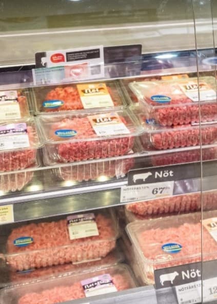 Tomma hyllor i en matbutik i Stockholm där nötkött brukar säljas, med få förpackningar kvar. Bilden illustrerar råvarubrist och påverkan på livsmedelsförsörjningen.