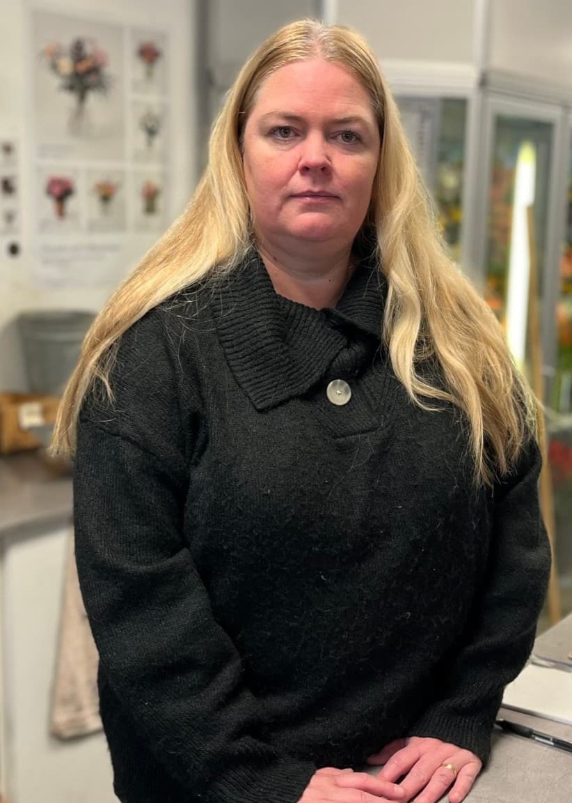 Bildmontage med en närbild av blomman liljekonvalj till vänster och en kvinna i svart tröja som står vid en receptionsdisk till höger.