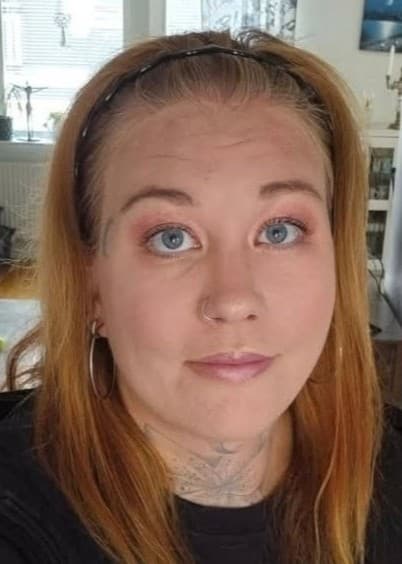 Gabi Mattsson står i ett hemmiljö med ljus inredning.