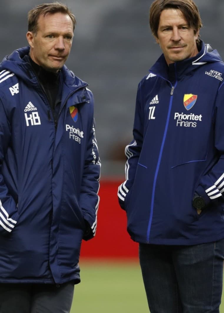 Djurgårdens tränare Kim Bergstrand och Thomas Lagerlöf står på planen i träningskläder före fotbollsmatchen mot Falkenbergs FF på Tele2 Arena i Allsvenskan.
