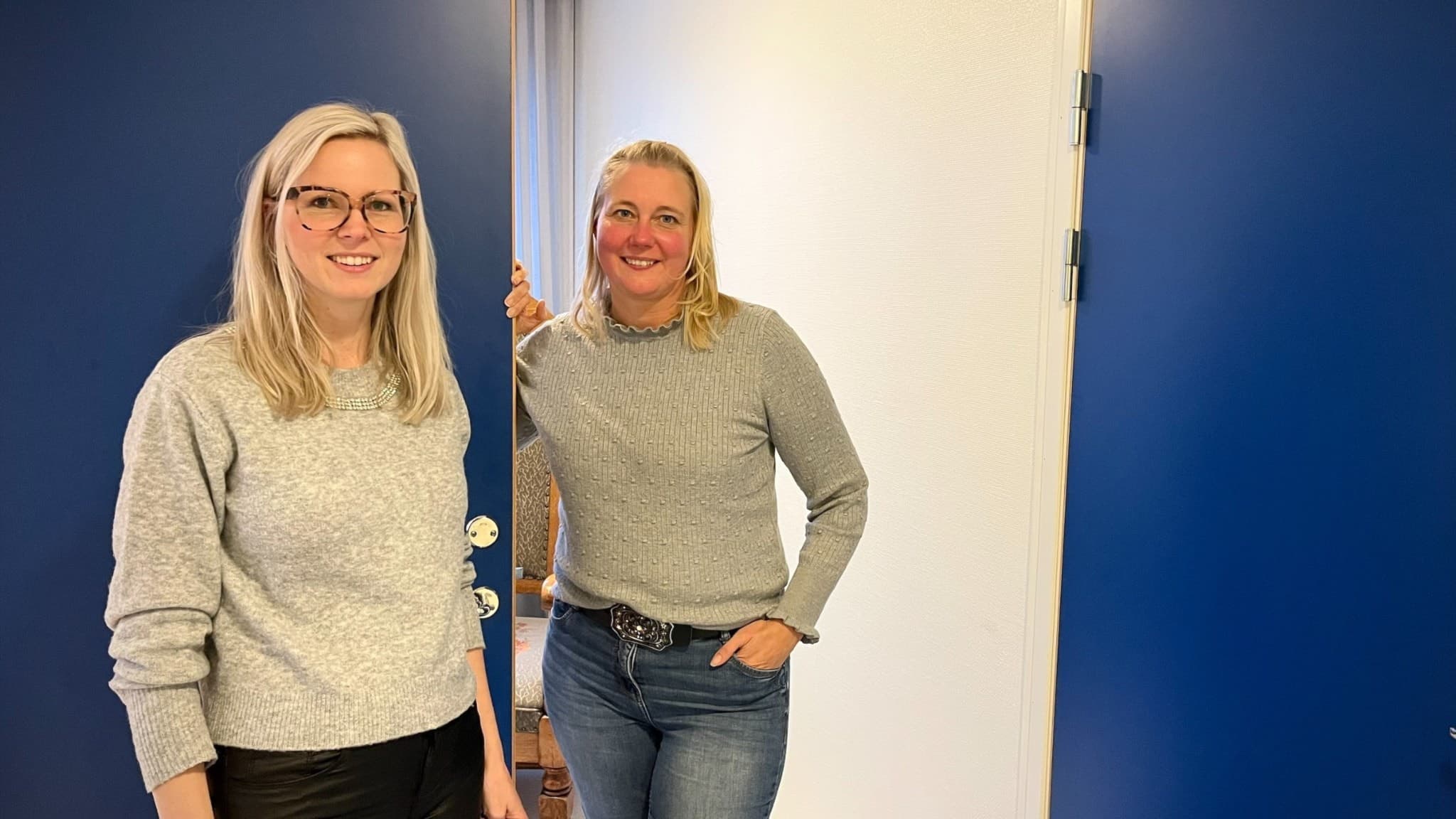 Anna Andresen och Elin Luckmann står i en korridor med blåa dörrar.