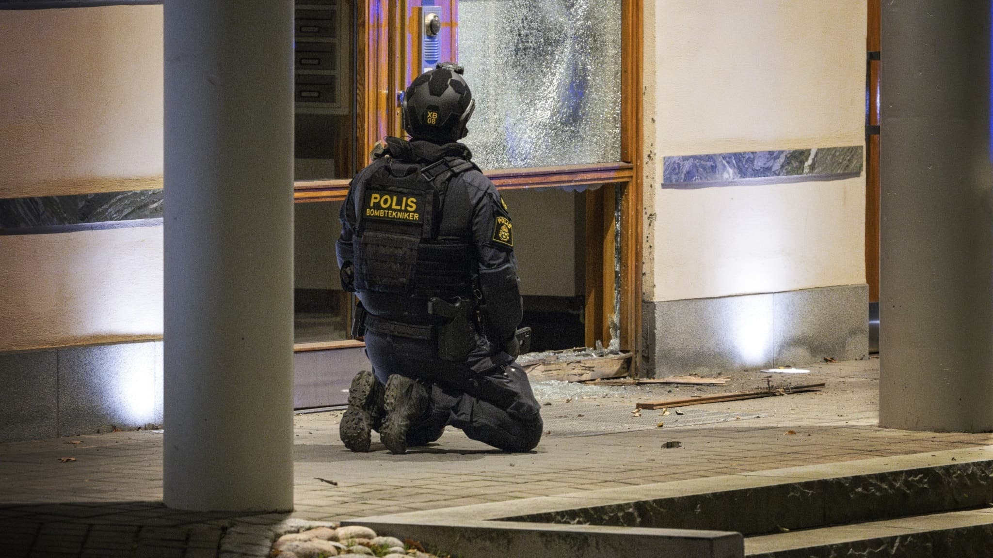 Polis utanför en söndersprängd port.