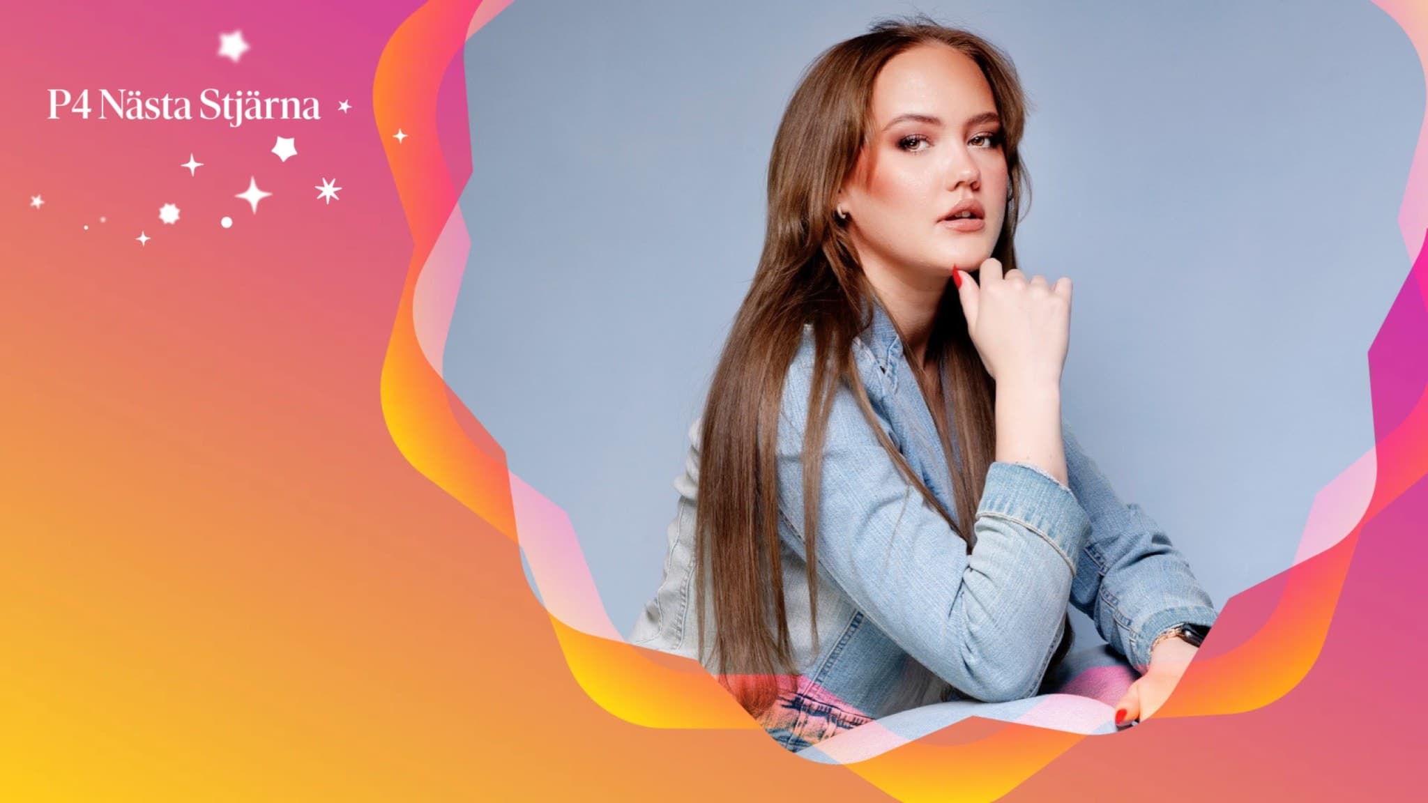 Bella Swartz, finalist i P4 Nästa Stjärna Göteborg, poserar framför en färgglad bakgrund med långt brunt hår och en jeansjacka, med handen lätt vid ansiktet.