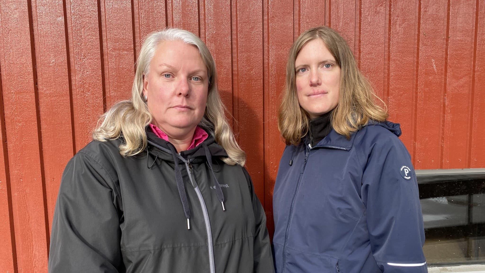 Anna Henriksson och Alexandra Bertilsson. De två kvinnorna står utomhus med jackor på sig, framför en rödmålad träfasad.