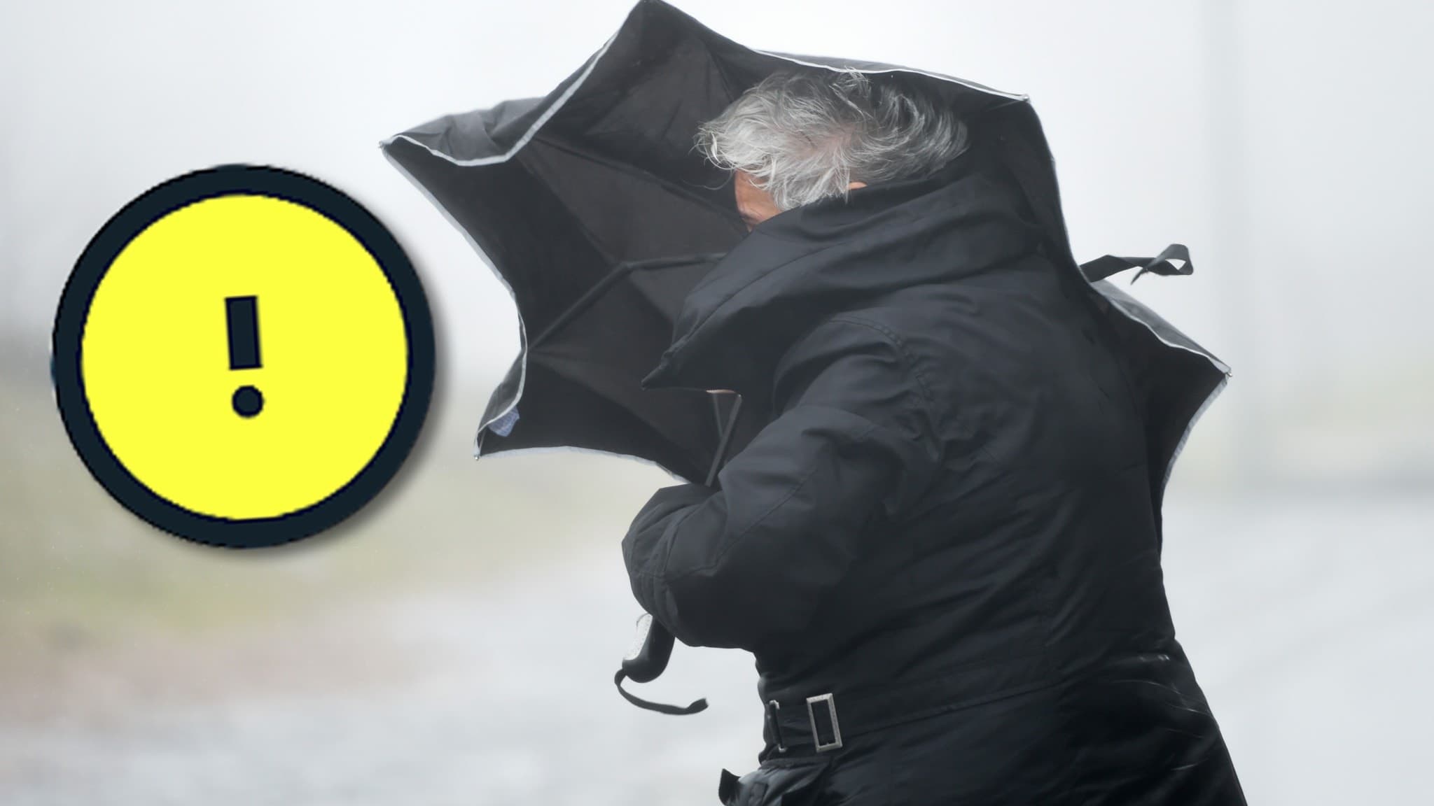 Kvinna med paraply i kraftig blåst