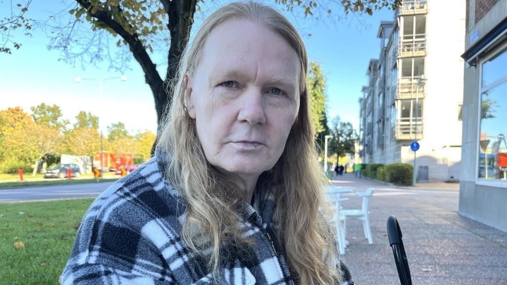 Jan sitter vid en bänk utomhus.