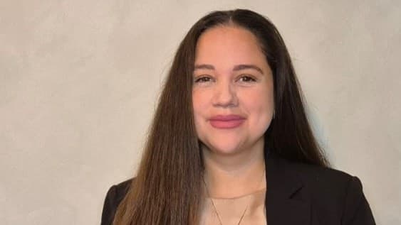 Amanda Gonzalez Bengtsson, klädd i svart kavaj och med långt brunt hår, står framför en ljus bakgrund. Hon är författare till boken 'Dejtingmetoden'.