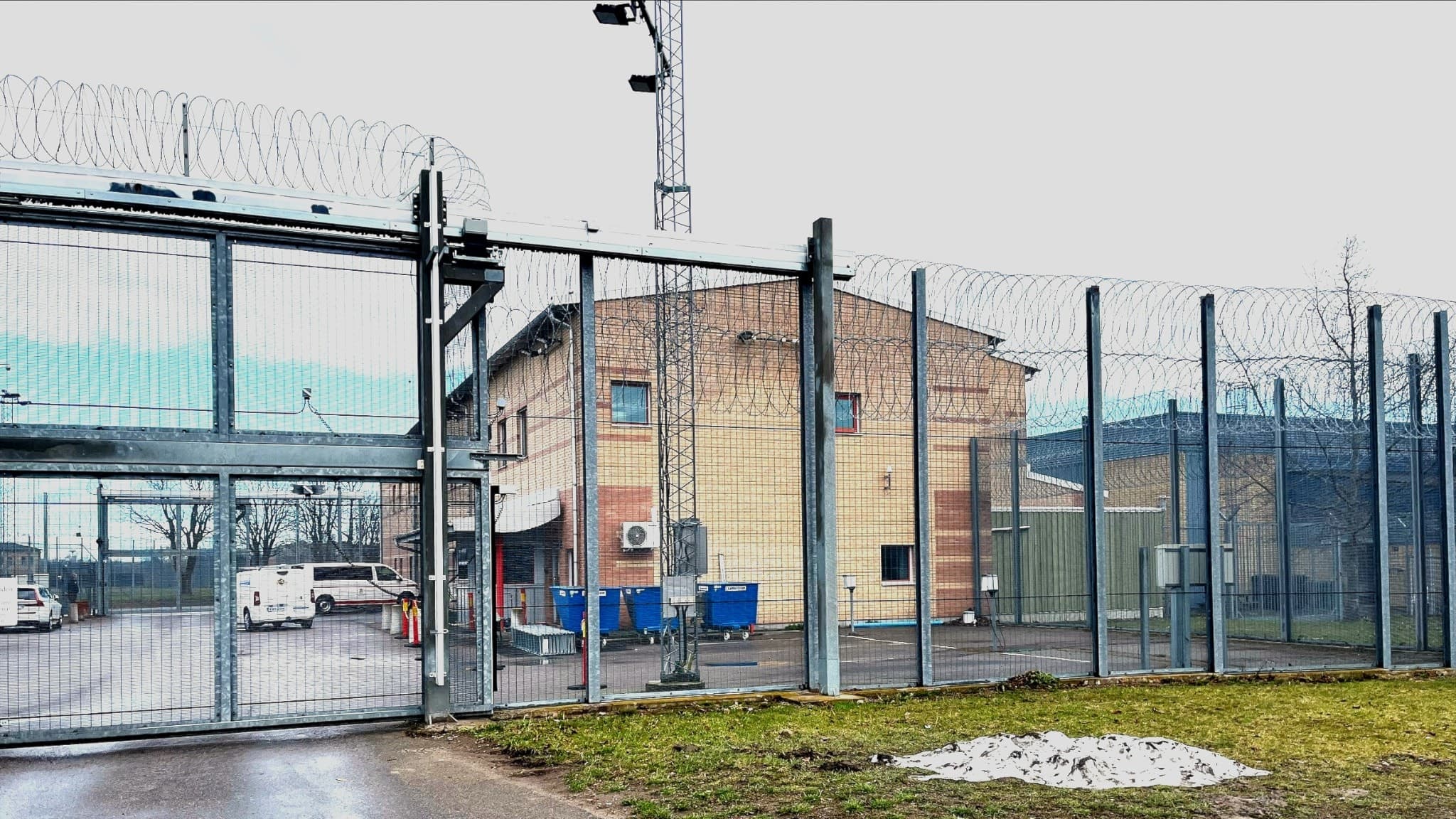 Skänningeanstalten med höga stängsel och taggtråd. Byggnaden syns i bakgrunden med flera säkerhetsdetaljer, inklusive övervakningskameror. En gräsyta och snöfläckar finns i förgrunden.
En strejk gällande maten har brutit ut på anstalten.