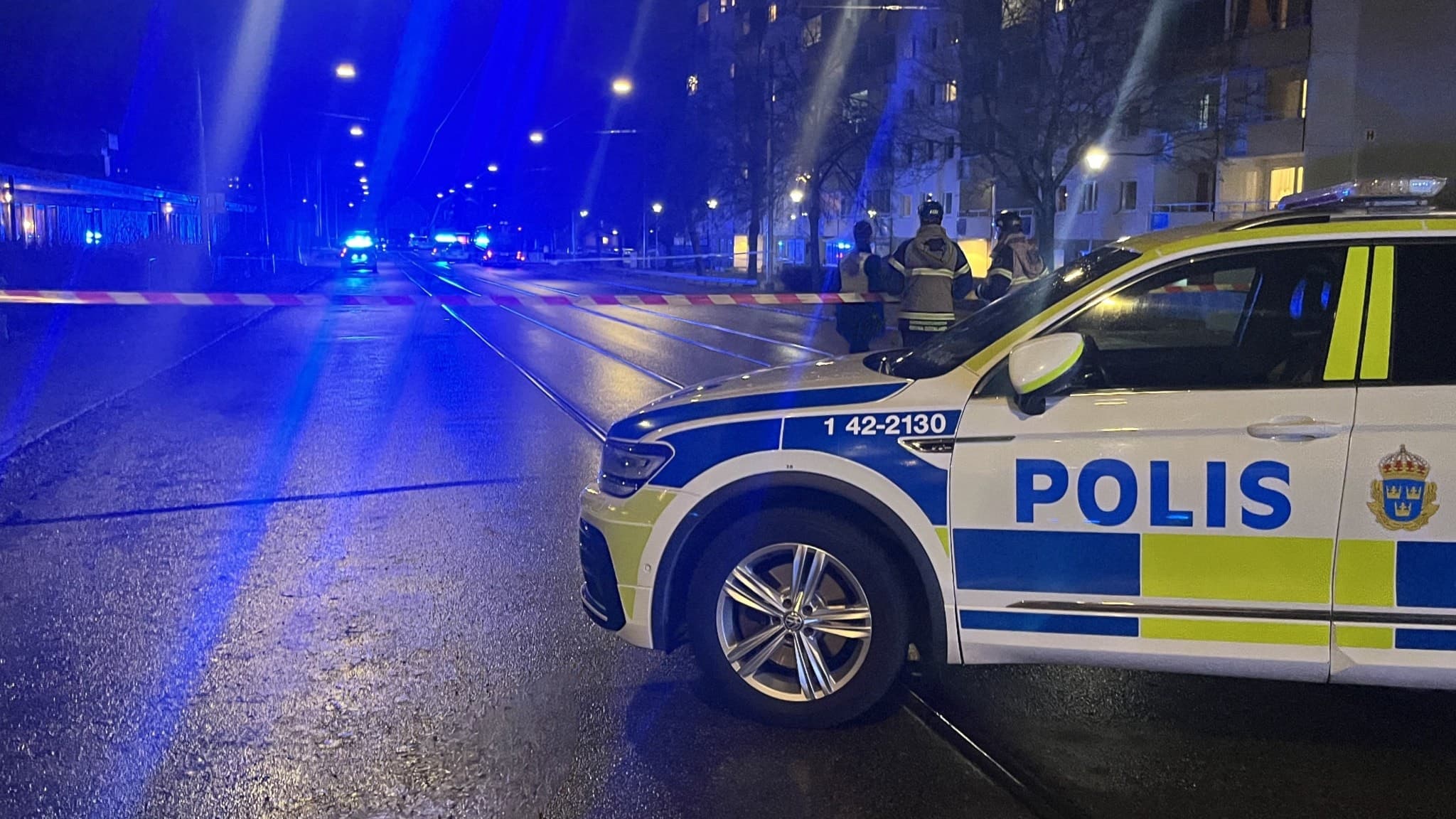 Polisbil och avspärrningar vid en nattlig skottlossning i Norrköping. Blåljus lyser upp gatan där flera poliser arbetar. Det grova våldet oroar och utreds av polisen.