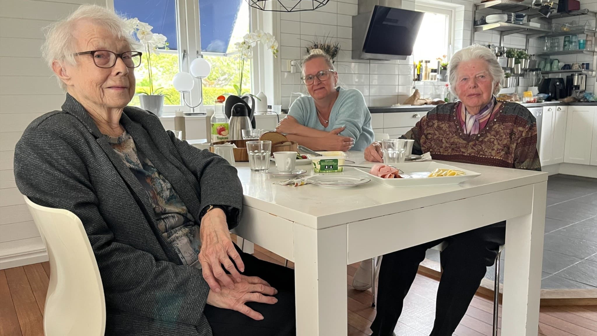 Kerstin Ny och Gudrun Andersson sitter vid ett bord tillsammans med fikagruppens ledare Linda Bohlin. 