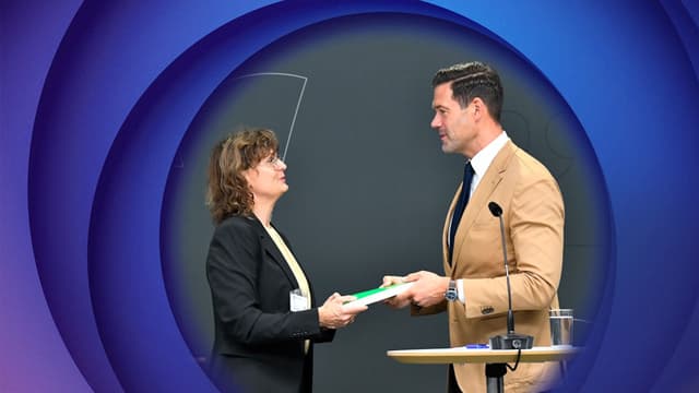 The lead author of the inquiry Ingrid Utne hands over her report to Migration Minister Johan Forssell.