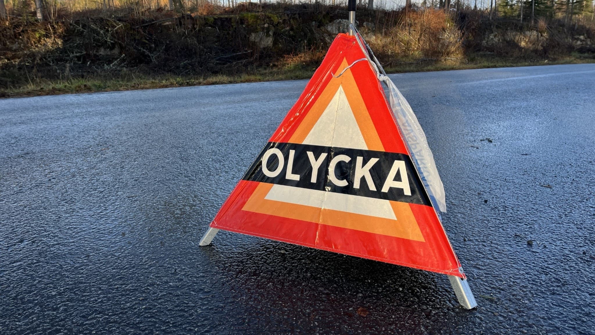 Triangulär skylt på marken som det står olycka på.