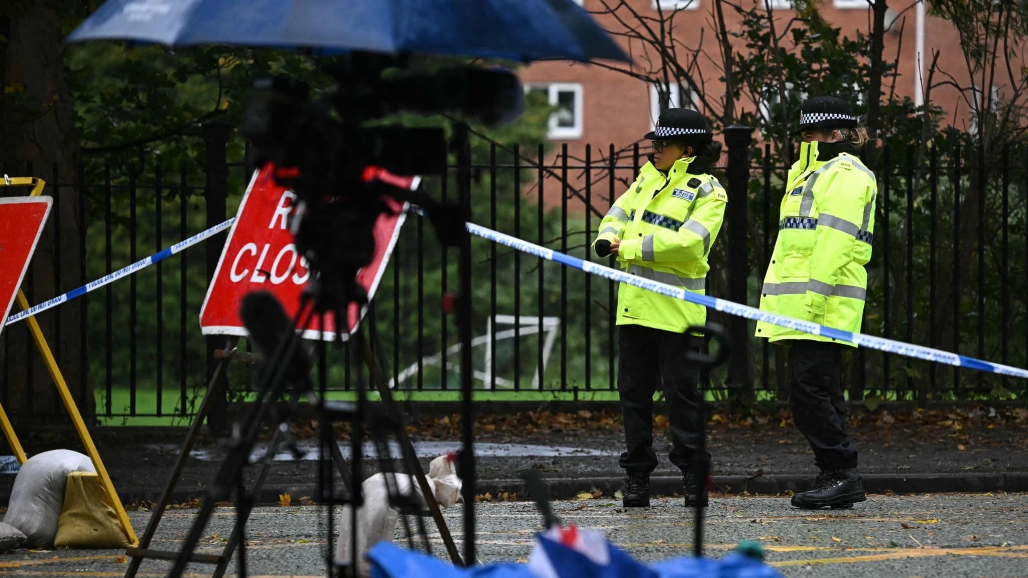 Två poliser står vid avspärrningar utanför Heaton Park Hebrew Congregation i Manchester efter en attack vid synagogan som resulterade i två döda och flera skadade under Yom Kippur.