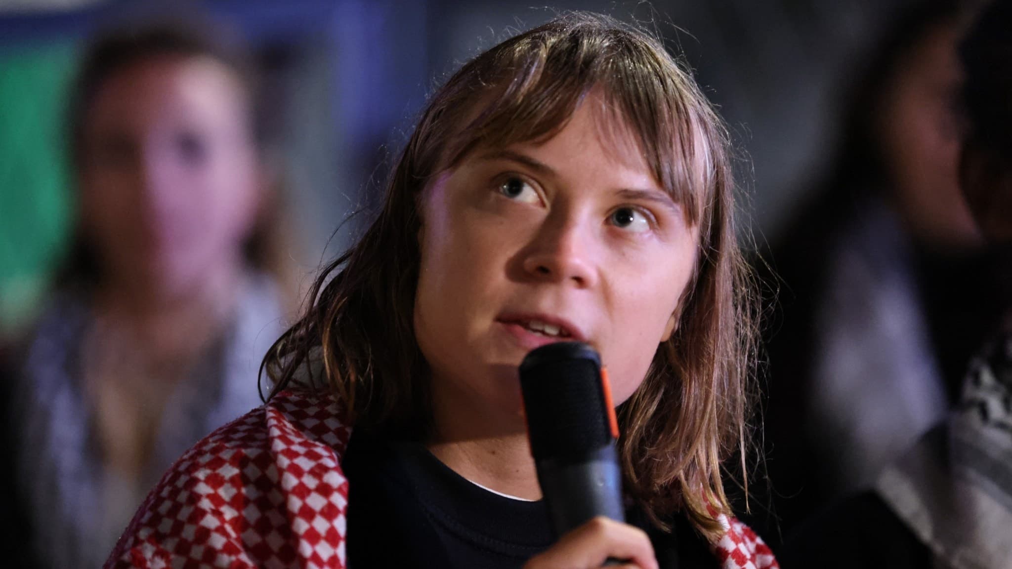 Aktivisten Greta Thunberg håller i en mikrofon.