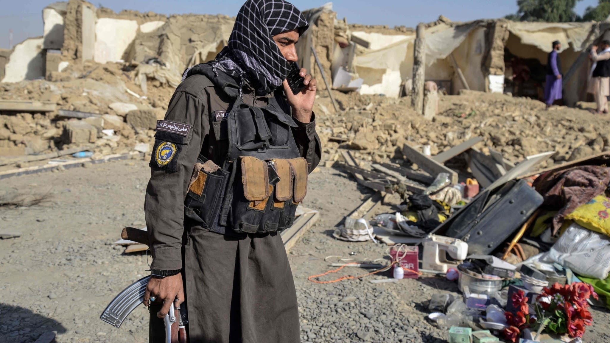 En talibansk säkerhetspersonal står med vapen vid ett skadat hus i Spin Boldak-distriktet, Kandahar-provinsen, Afghanistan, efter gränsstrider mellan Afghanistan och Pakistan.