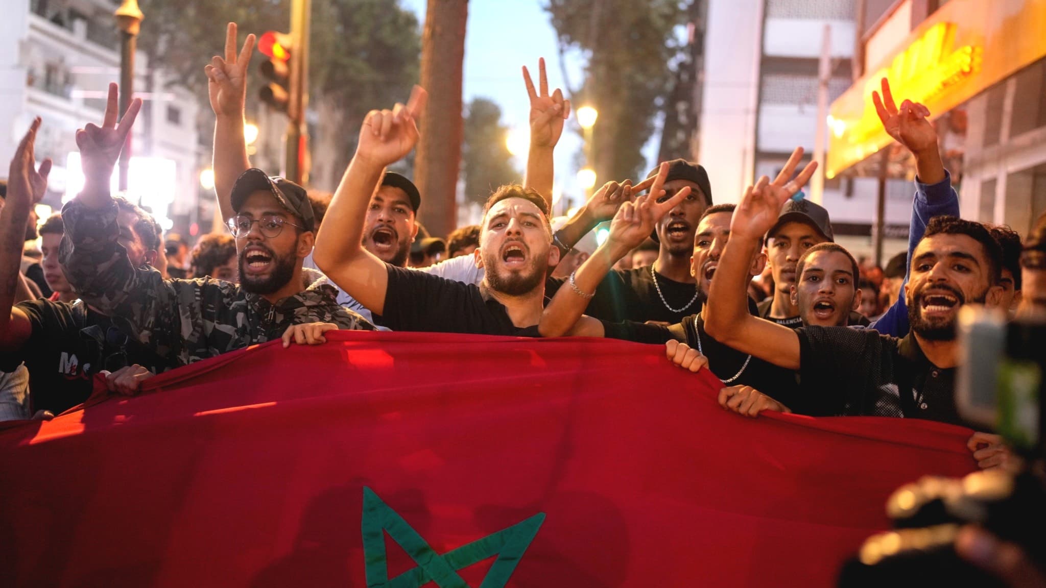 Demonstranter i Rabat, Marocko, håller upp landets flagga och gör segertecken under en protest mot korruption samt för reformer inom sjukvård och utbildning.