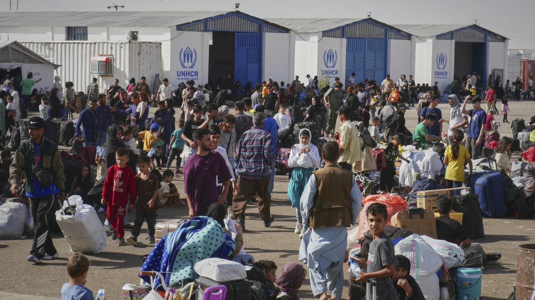 Afghanska flyktingar som återvänt från Iran samlas vid ett UNHCR-center nära Islam Qala-gränsövergången i Heratprovinsen, Afghanistan. Många bär bagage och väntar på hjälp.