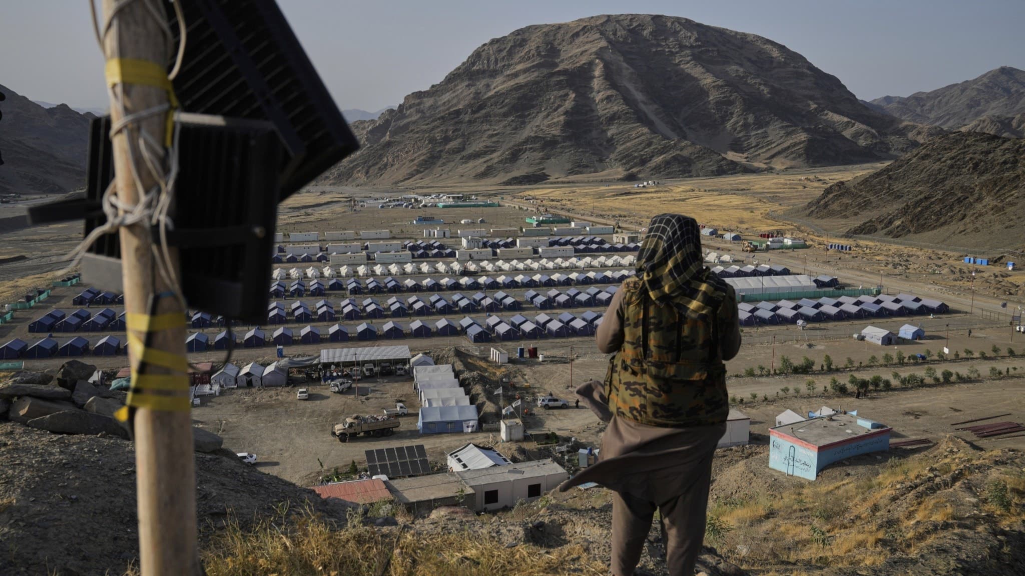 En talibankrigare står på en kulle med utsikt över ett flyktingläget, nära gränsen mellan Pakistan och Afghanistan. Arkivbild.