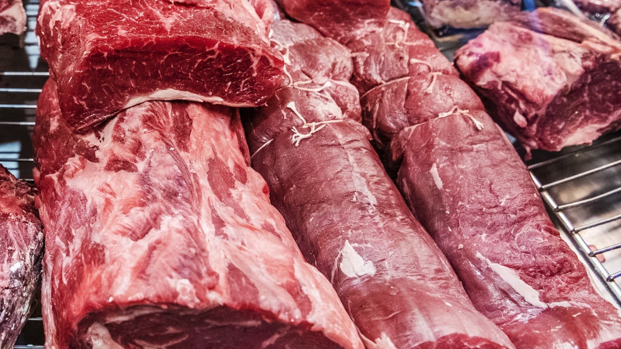 Köttstycken ligger på rad i en köttdisk, med fokus på röda köttbitar. Bilden är från Hötorgshallen i Stockholm och illustrerar försäljning av rött kött.