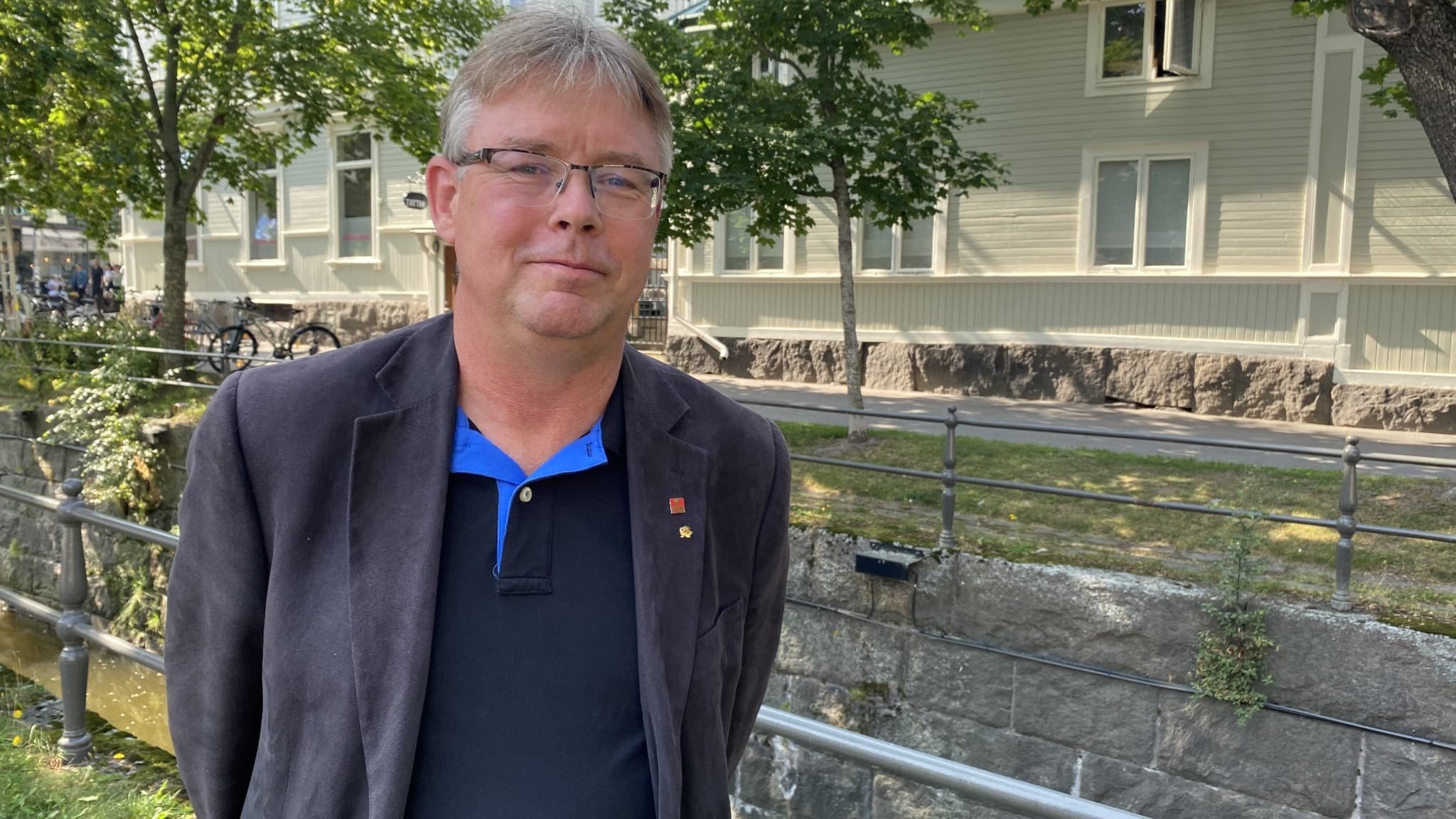 En man står utomhus i stadsmiljö.