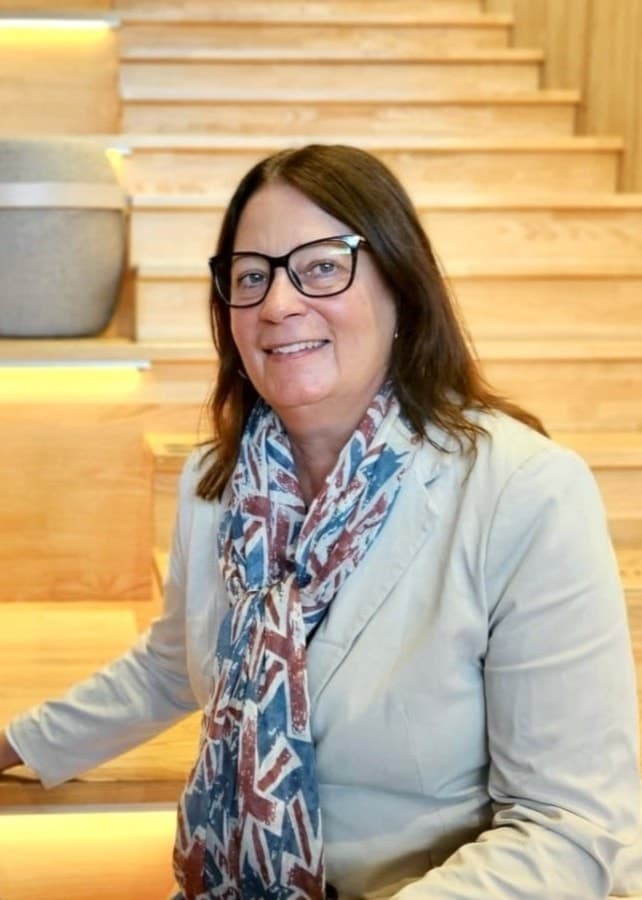 Linda Peterson och Eva Kalén från Telin Rekrytering & Konsult sitter framför en trätrappa med modern inredning i bakgrunden, iklädda kavajer och sjalar.