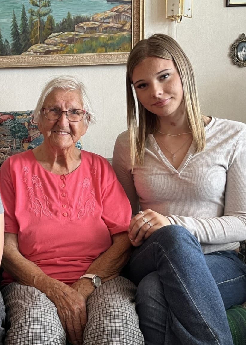 Noah Olsen, Ingrid Hansson och Ronja Biresev Eriksson sitter tillsammans i en soffa i ett vardagsrum med tavlor och prydnadssaker i bakgrunden.