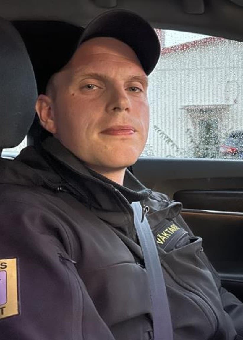 En väktare, identifierad som Tim Hagberg, sitter i en bil. Till vänster syns dunkar som fylls med diesel från en lastbil. Bilden visar misstänkt bränslestöld.