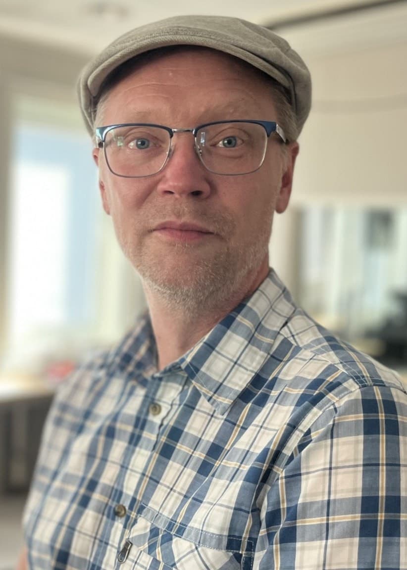Christer Öberg sitter i en radiostudio med mikrofoner runt sig, klädd i en rutig skjorta och keps. Han har nyligen släppt boken ”Triangeldrama i Jock” om släktens komplicerade historia.