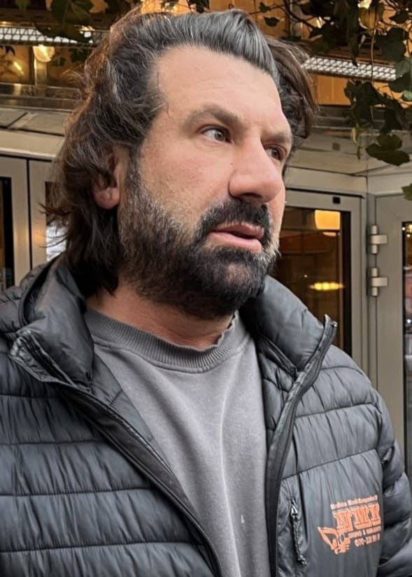 Shahriar Rad, anställd på en pub i Gävle, står utanför lokalen där hans kollegor hjälpte skadade efter en skottlossning. Bakgrunden visar pubens fasad med glödlampor och dekorationer.