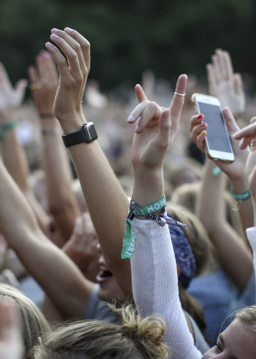 Festivalpublik med händer i luften under en konsert på Way Out West i Slottskogen, Göteborg. 