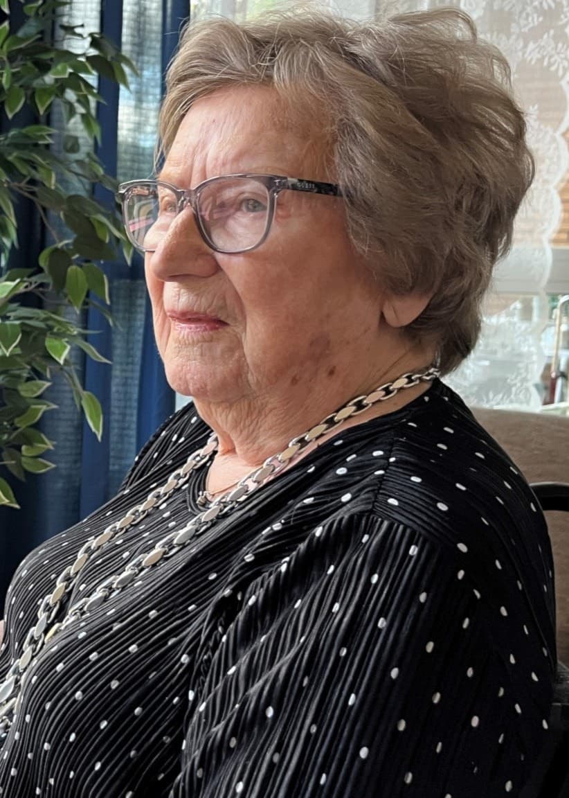 95-åriga Irma Engström i sin rullstol tittar ut genom ett fönster. 