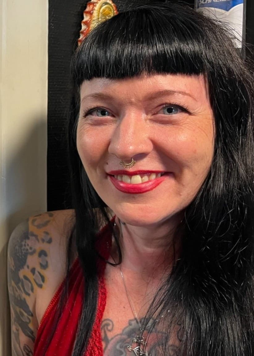 Två personer med synliga tatueringar står inomhus vid ett drop-in evenemang för tatueringar under Nerikes Pride, med ljusa väggar och en spegel i bakgrunden. Madeline Pettersson till vänster och Lisa Engberg till höger.