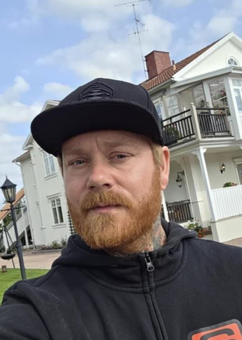 En man med rött skägg och keps bredvid en bild på en igelkott i en soptunna.