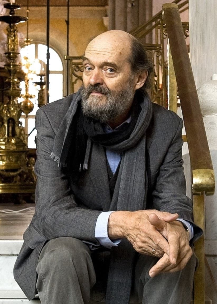 Tonsättaren Arvo Pärt sitter i en trappa i Vasakyrkan i Stockholm. 