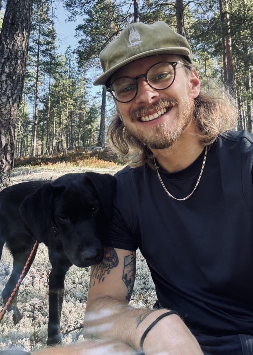 En stor skräphög med blandat avfall, inklusive kartonger, plast och metall, ligger vid en skogskant i Tranås. Bilden visar miljöförstöring och olaglig dumpning i naturen.