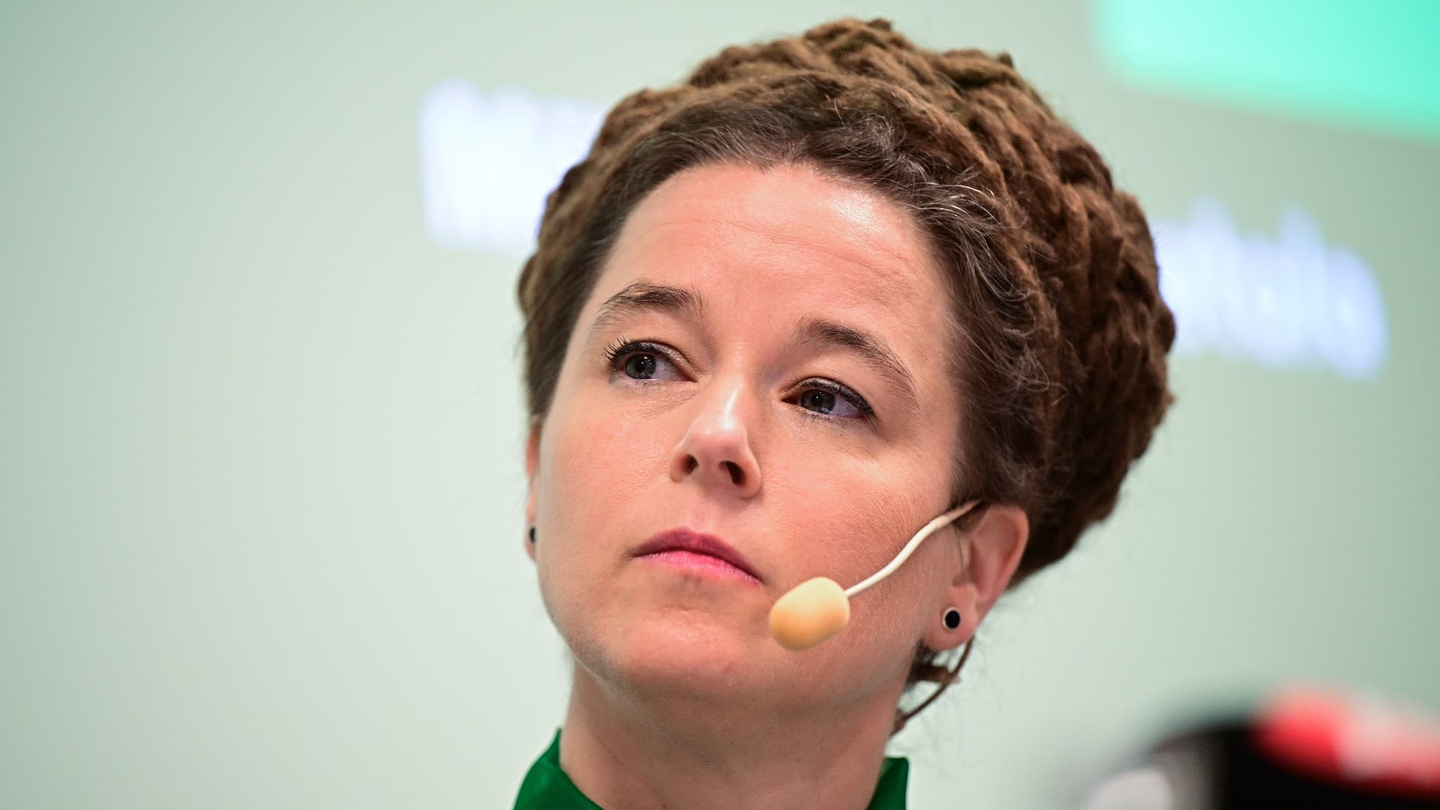 Miljöpartiets språkrör Daniel Helldén och Amanda Lind står vid ett podium med mikrofoner under en pressträff på Miljöpartiets kongress i Västerås. En vattenkaraff och glas syns på bordet.
