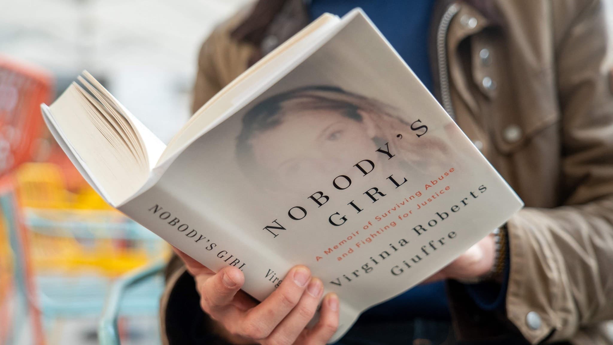 En person håller i en bok med titeln 'Nobody's Girl'.