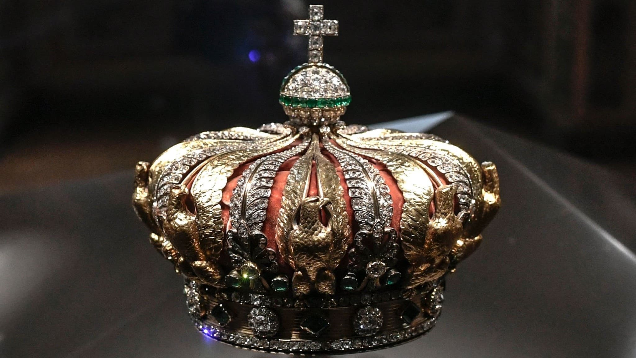 En utsmyckad krona tillhörande Eugénie de Montijo, tidigare kejsarinna av Frankrike, visas upp på Louvre-museet. Kronan är dekorerad med diamanter och smaragder, placerad på en glasmonter.